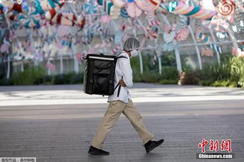 資料圖：當?shù)貢r間2021年1月4日,，泰國曼谷,，一名快遞員“全副武裝”走在街頭。