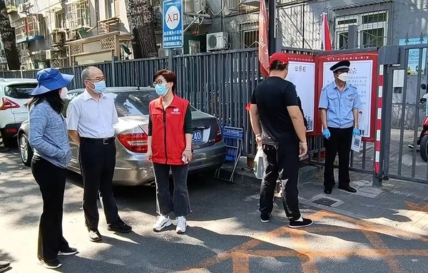 湯欽飛主席到東直門街道新中街社區(qū)檢查小區(qū)出入口登記掃碼情況