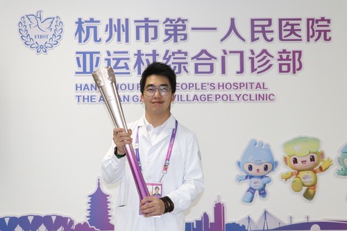 吳玨燦和杭州亞運(yùn)會(huì)火炬“薪火”合影（人民政協(xié)報(bào)社,，受訪者供圖）