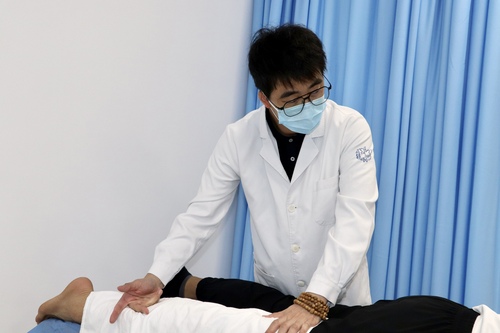 吳玨燦為運(yùn)動(dòng)員做中醫(yī)推拿（人民政協(xié)報(bào)社，受訪者供圖）