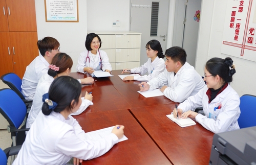 毛莉（居中）與同事們一起討論工作,。（圖片由受訪者提供）
