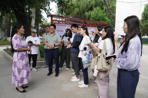 △在新源縣喀拉布拉鎮(zhèn),，賈娜爾委員（左一）接受記者采訪,。