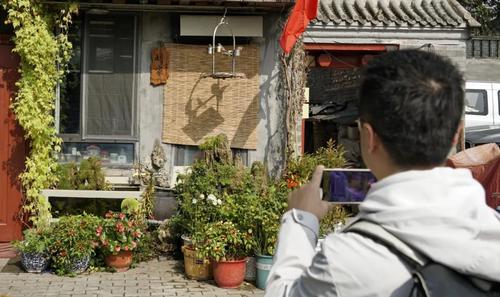 ▲一名游人在鐘樓灣胡同內(nèi)參觀拍攝,。新華社記者李欣 攝