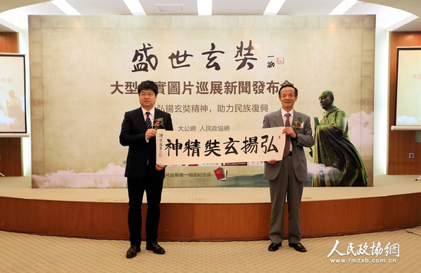 中國(guó)佛教協(xié)會(huì)常務(wù)理事陳星橋與大公報(bào)社長(zhǎng)助理,、北京分社社長(zhǎng)、大公網(wǎng)執(zhí)行總裁兼總編輯王文韜展示中國(guó)佛教協(xié)會(huì)駐會(huì)副會(huì)長(zhǎng)演覺(jué)法師的墨寶——《弘揚(yáng)玄奘精神》（攝影：姚勇）