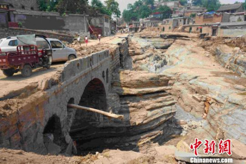 此次山洪將臺(tái)頭村公路連同下面的垃圾完全沖走，暴露出古河道當(dāng)年的面貌,?！埛?攝